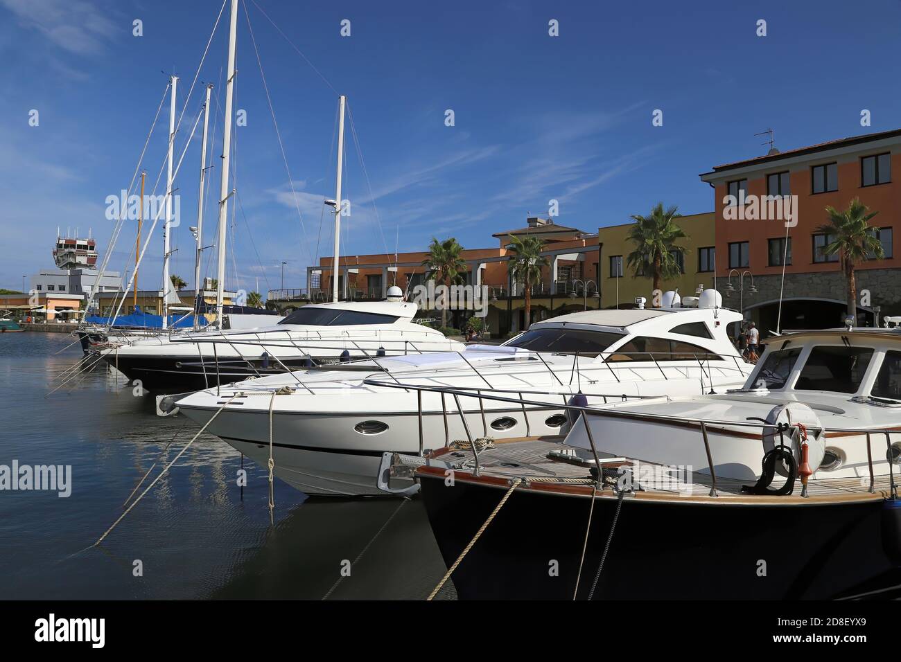 Front perspective of Luxury yachts and sailing boats moored at Marina Genoa Airport against a nice blue sky. Stock Photo