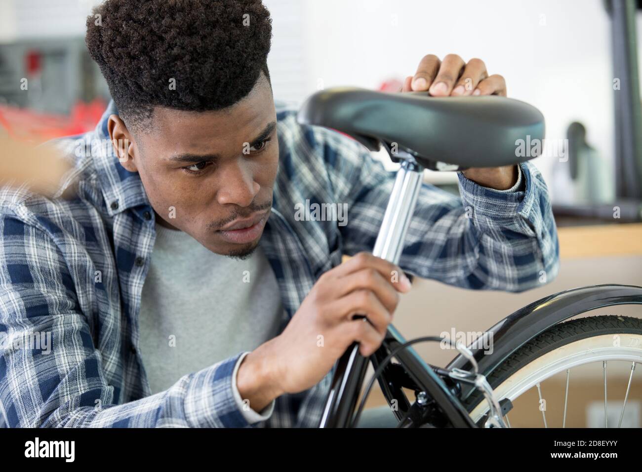 man adjusting a bicycle seat Stock Photo Alamy