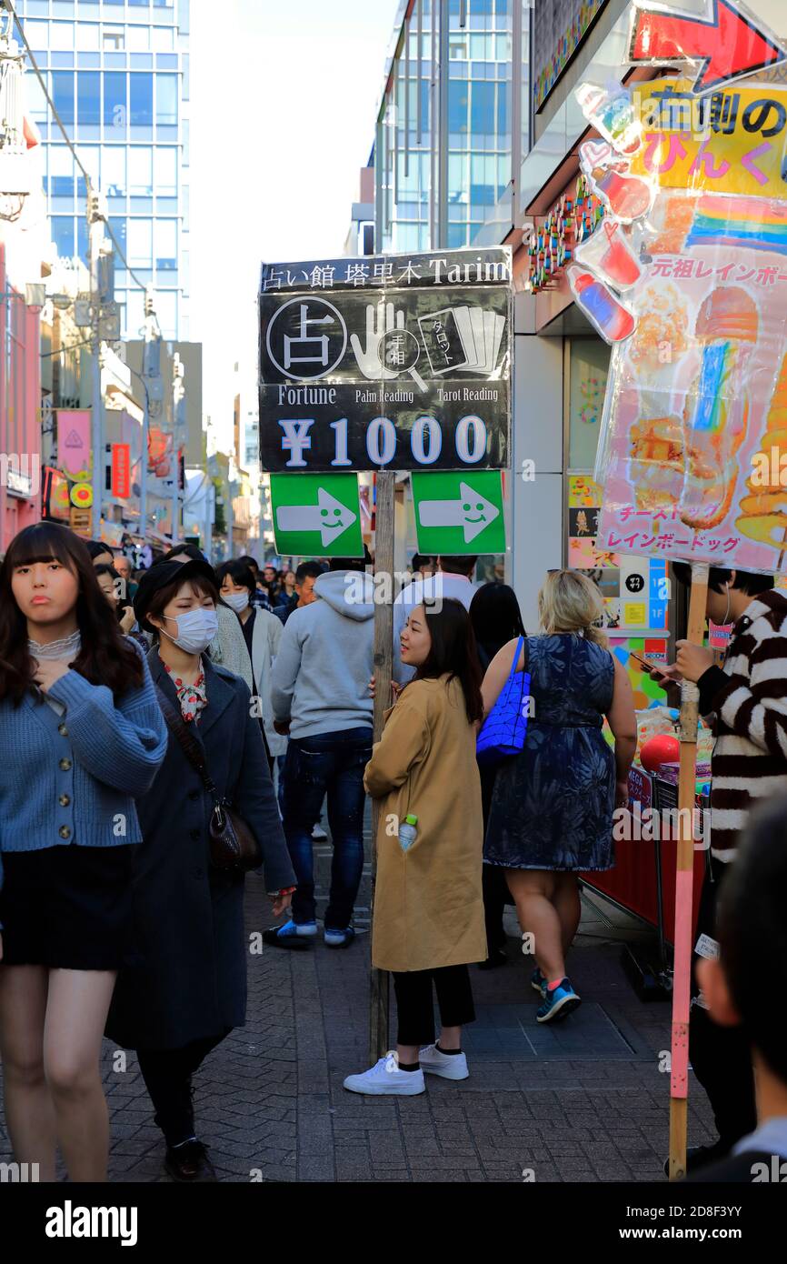 A young woman holding a sign board for fortune telling in Takeshita Street.Harajuku.Shibuya.Tokyo.Japan Stock Photo