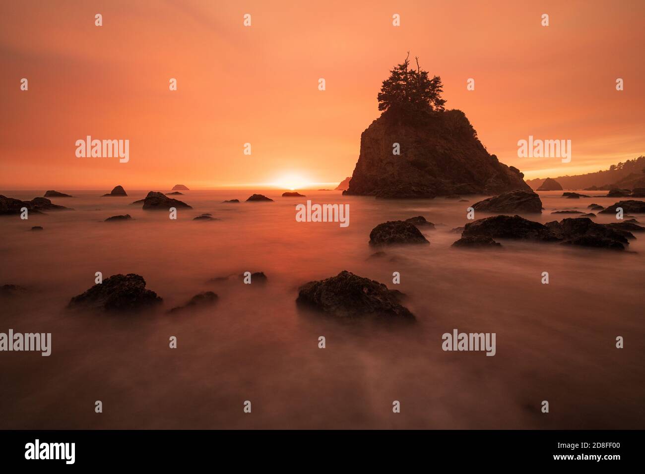 Smokey sunset over a sea stack on a beach in Trinidad along the remote scenic drive in the small fishing community of Trinidad on California's Pacific Stock Photo