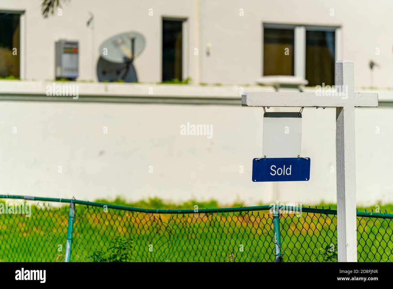 Sold real estate sign. with home in background Stock Photo - Alamy