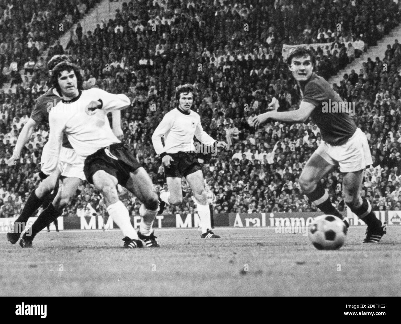 FILED - 26 May 1972, Munich: Watched by his team-mate Jupp Heynckes (M), German striker Gerd Müller (l, front) scores the 1-0 lead in the international football match against the USSR in front of 80,000 spectators in the newly opened Olympic Stadium. (to dpa 'The 'Bomber' becomes 75: Gerd Müller 'cannot be lifted high enough') Photo: dpa Stock Photo