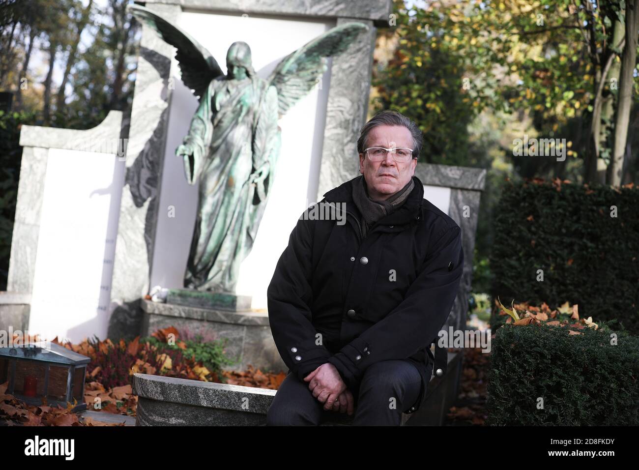 Cologne, Germany. 28th Oct, 2020. Christoph Kuckelkorn, funeral director and carnival president, is sitting at a grave in the Melatenfriedhof. (to dpa 'With carnival president Christoph Kuckelkorn at the Melatenfriedhof') Credit: Oliver Berg/dpa/Alamy Live News Stock Photo