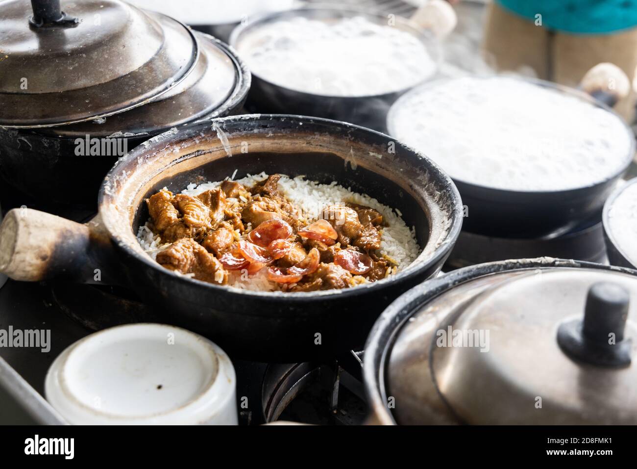 Steamy hot clay pot chicken rice being cooked in restaurant. Popular