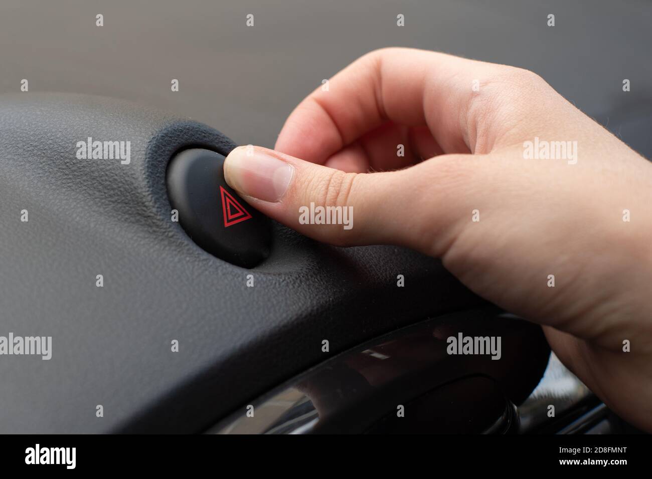 Closeup hand presses emergency stop button, road accident, danger and warning motorists on highway while traveling Stock Photo