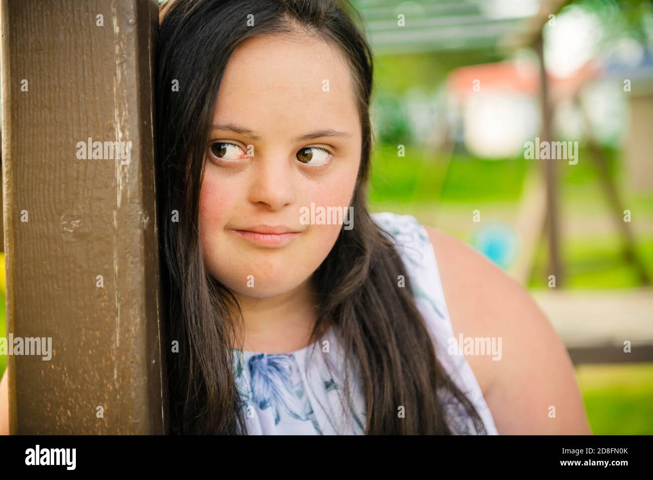 A Portrait of trisomie 21 adult girl outside at sunset Stock Photo