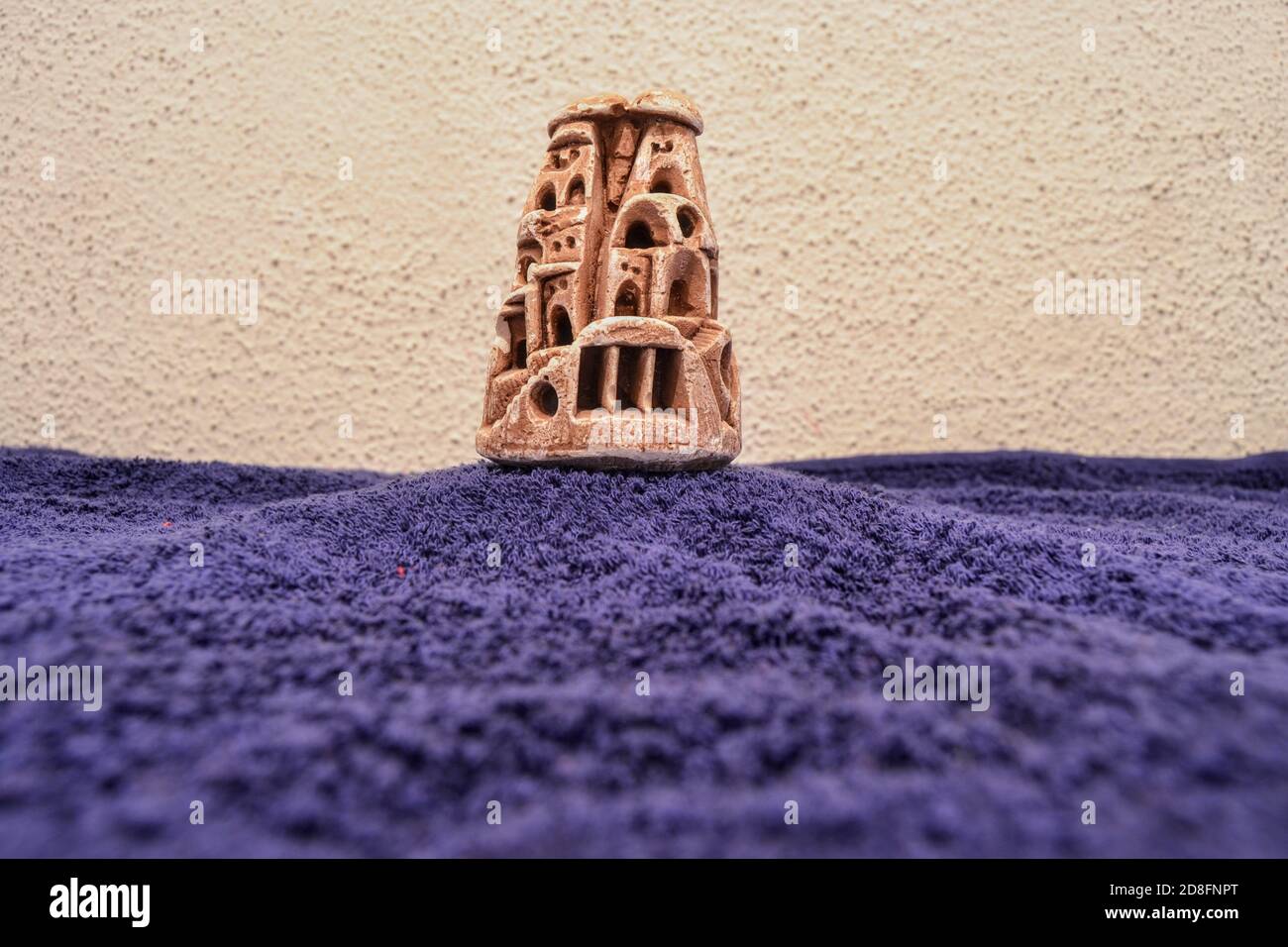 Cappadocia miniature trinket. Nevsehir Turkey. Ancient and miniature fairy chimneys Cappadocia with blue bottom and wall background. Stock Photo