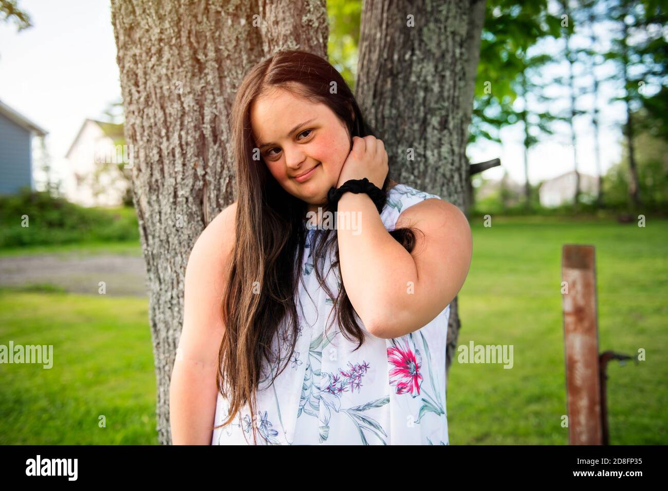 A Portrait of trisomie 21 adult girl outside at sunset Stock Photo