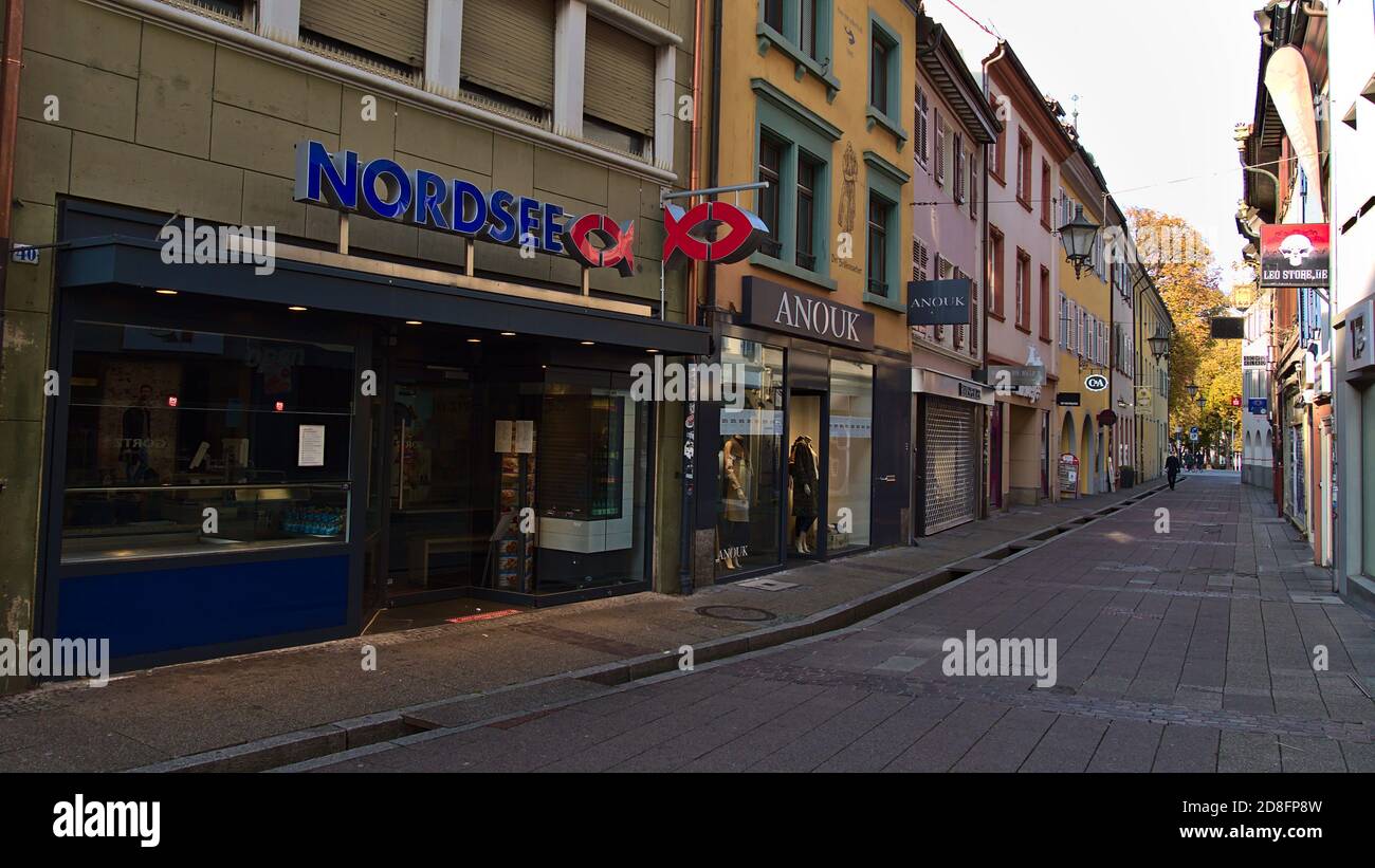 Freiburg, Baden-Wuerttemberg, Germany - 10/25/2020: Branch of fast food chain Nordsee (North Sea, specialized on seafood) in deserted narrow alley. Stock Photo