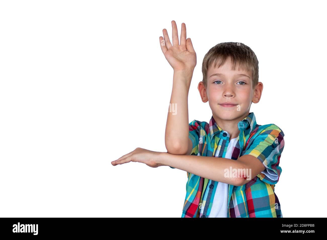 A smart, cute boy raises his hand to answer in class. Happy child against white board. Education concept, back to school Stock Photo