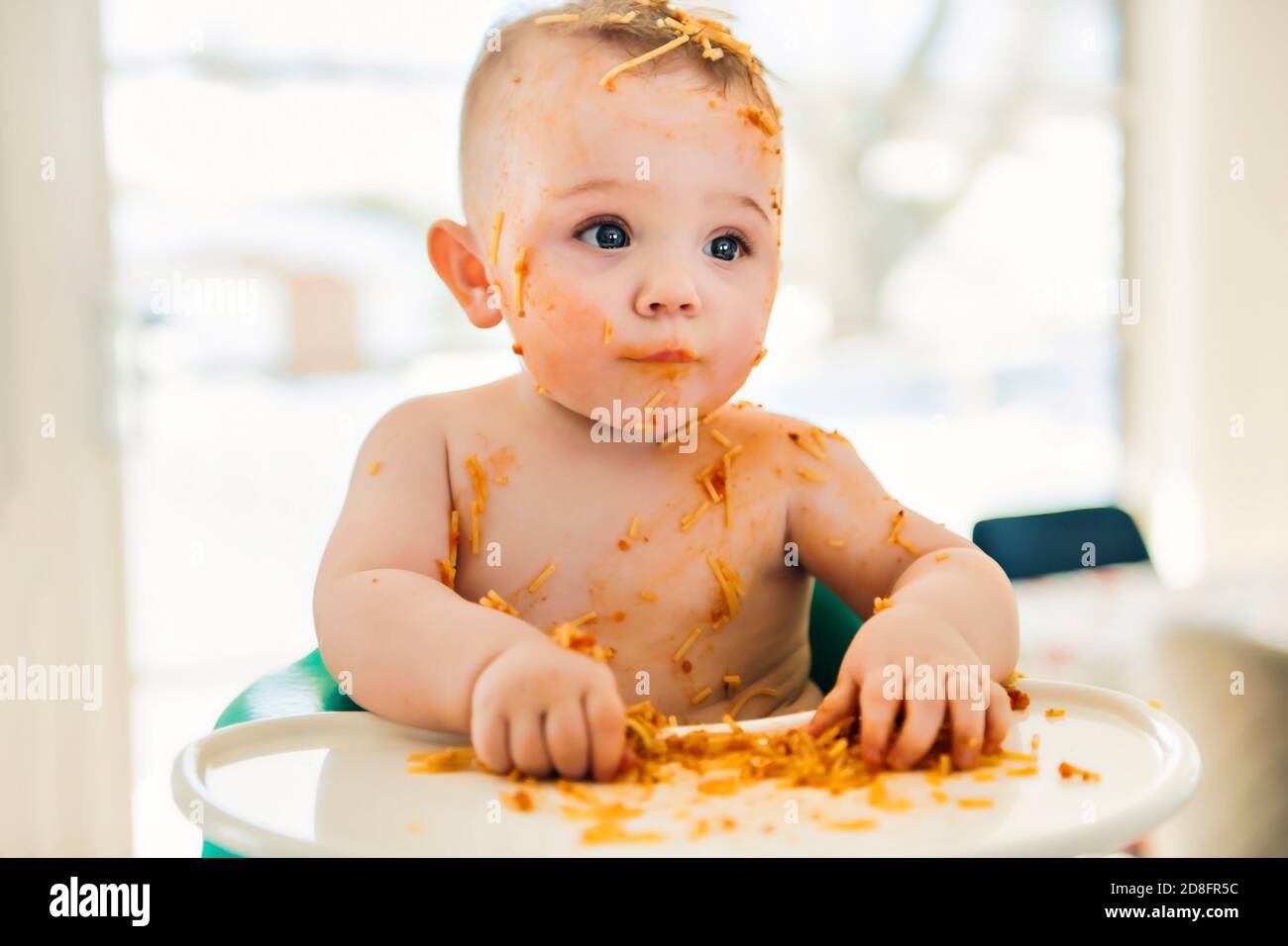 Little baby boy eating her dinner and making a mess Stock Photo Alamy