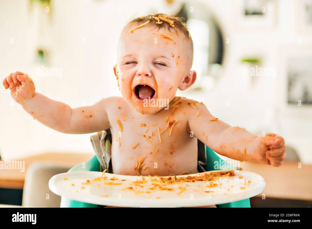 Little baby boy eating her dinner and making a mess Stock Photo