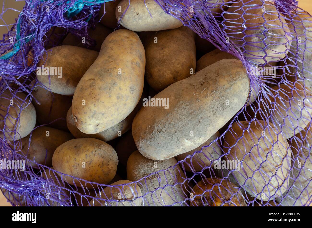 https://c8.alamy.com/comp/2D8FTD5/raw-potatoes-in-a-mesh-bag-close-up-vegetable-harvest-packed-in-mesh-bags-agronomy-without-people-2D8FTD5.jpg