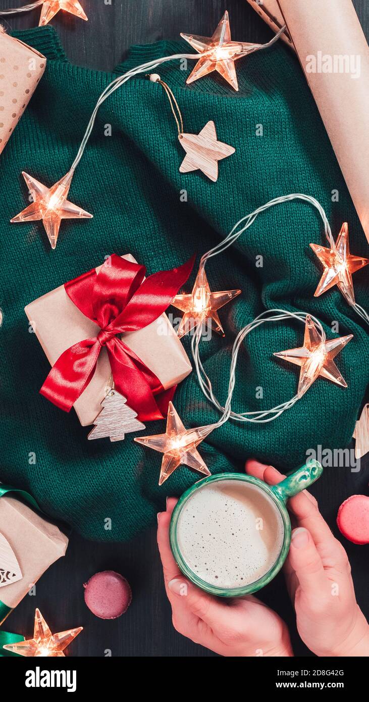 Christmas flat lay with craft gift boxes, garland lights and decorations on dark wooden background. Vertical format for mobile device Stock Photo