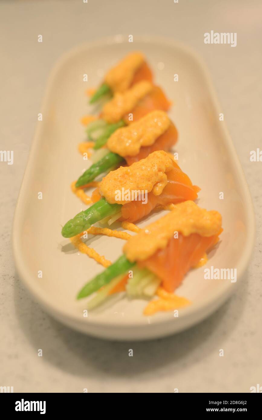 Salmon Roll With Asparagus And Fresh Cucumbers Garnished With Shrimp Sauce On Top Stock Photo