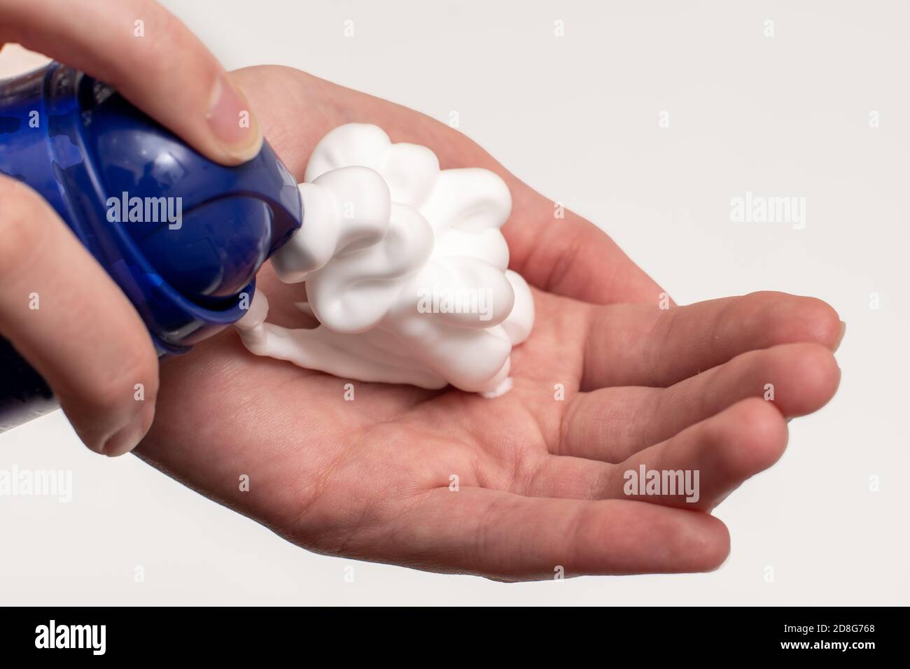 A close-up of a female hand squeezing foam in the palm of a hand. Place soap foam with foam on hand Stock Photo