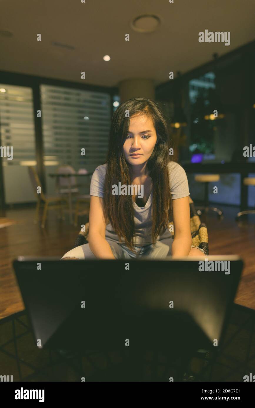 Young beautiful Asian woman using laptop in the living room Stock Photo ...