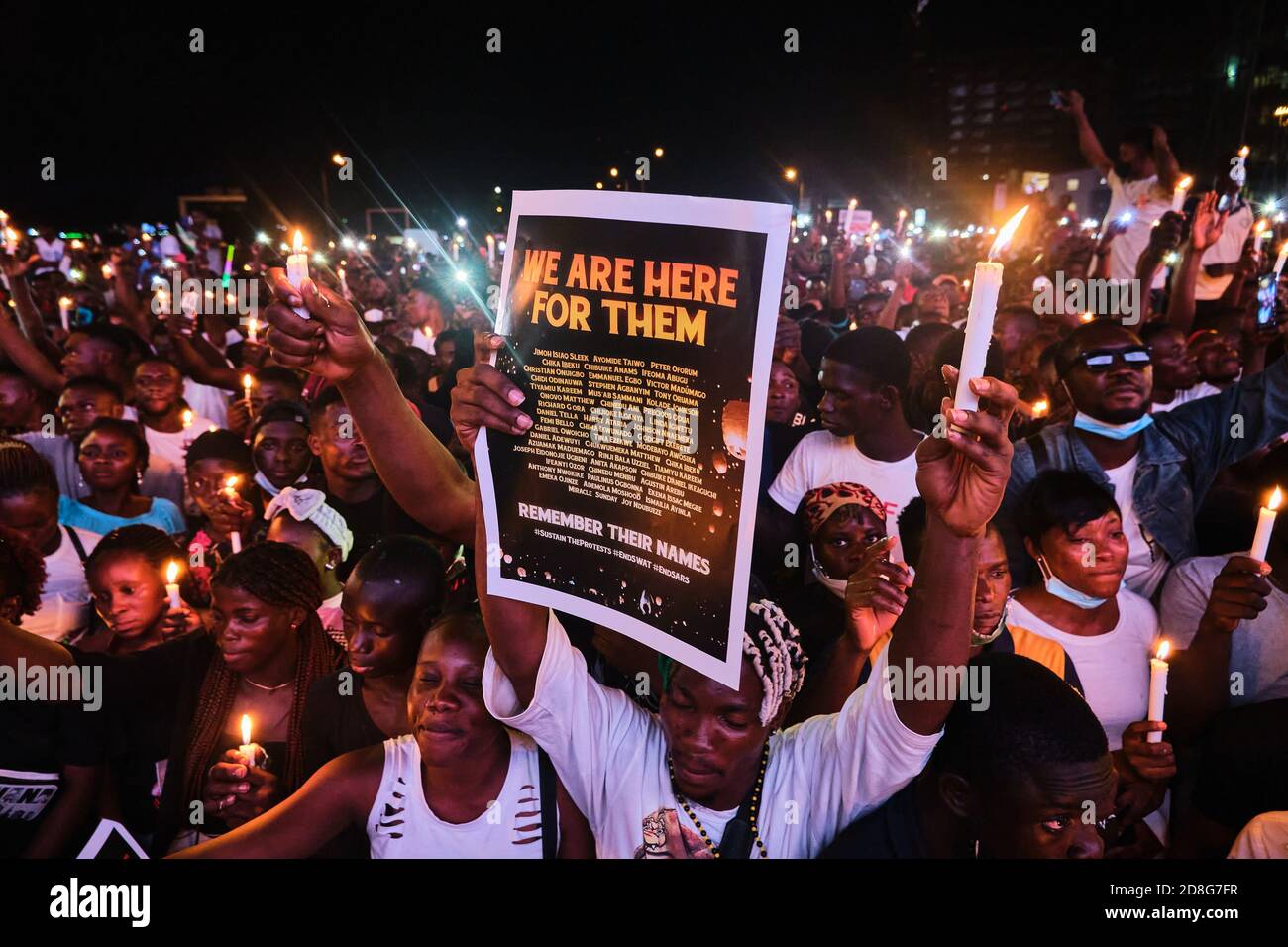 Protesters hold candlelight for victims of police brutality during protests tagged #EndSARS at the Lekki tollgate in Lagos Nigeria on October 16, 2020 Stock Photo