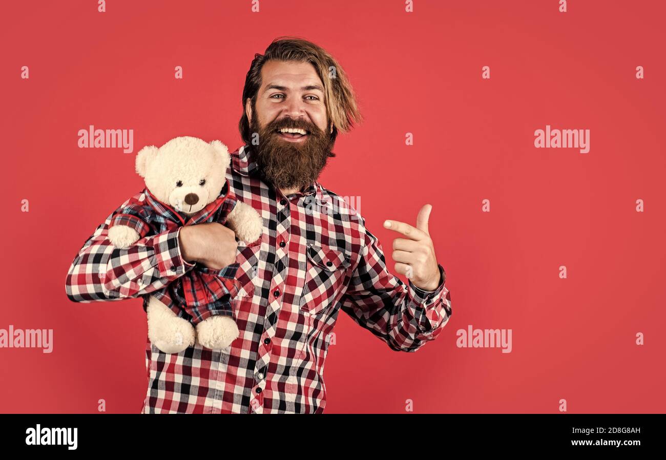 look at this. Guy with happy face plays with soft toy. Childish mood concept. guy enjoy valentines day. best present ever. Valentines day gift for beloved. Holiday celebration concept. Stock Photo