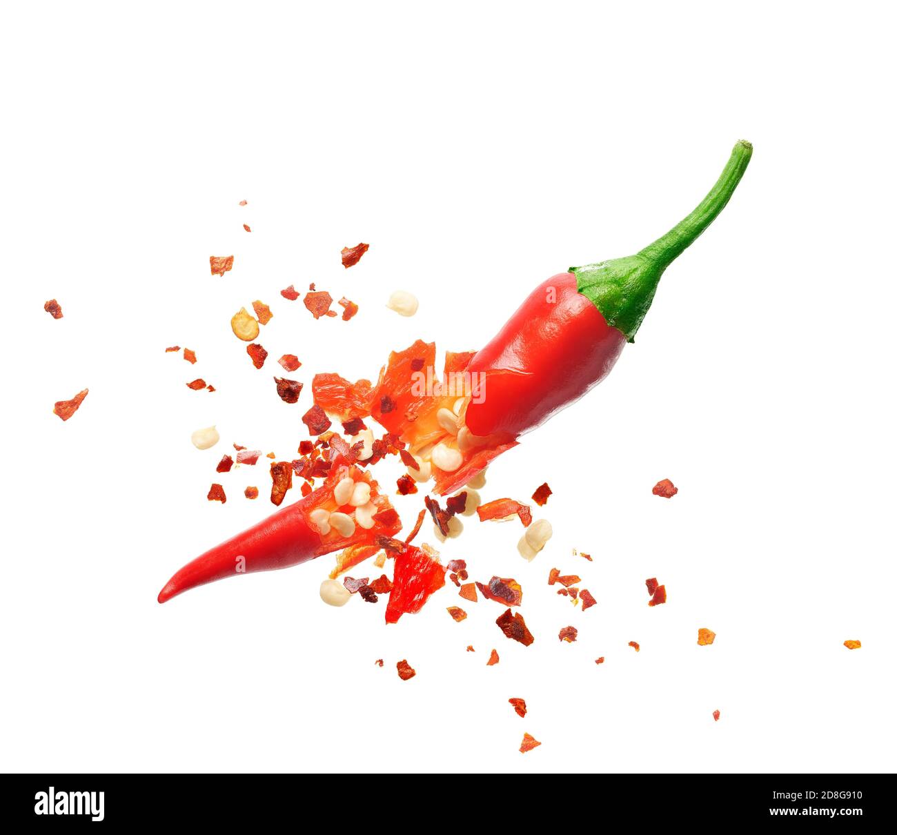 Chili flakes bursting out from red chili pepper over white background Stock Photo