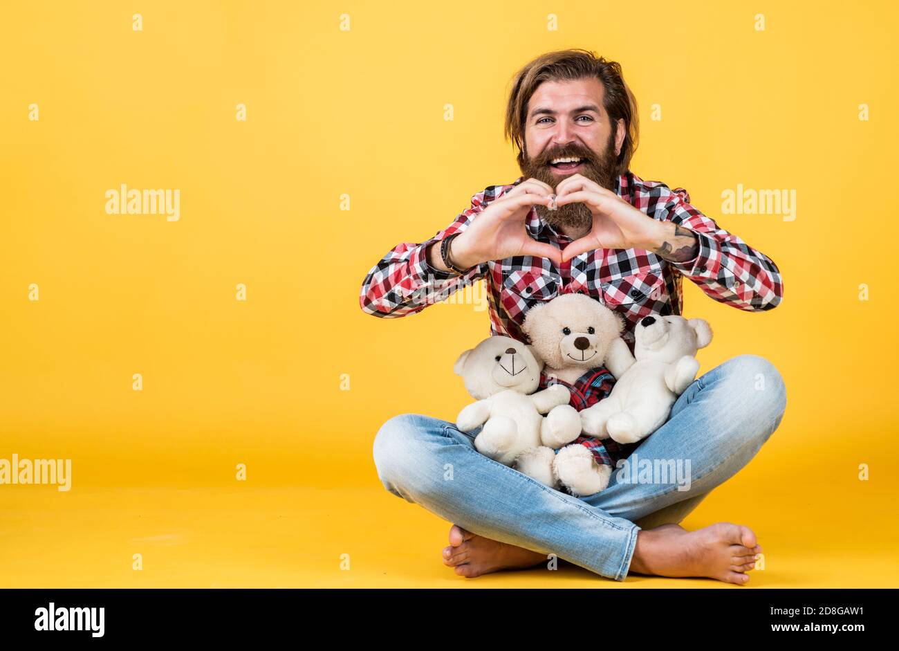 concept of love. Childish mood concept. guy enjoy valentines day. best present ever. Valentines day gift for beloved. Holiday celebration concept. Guy with happy face plays with soft toy. Stock Photo