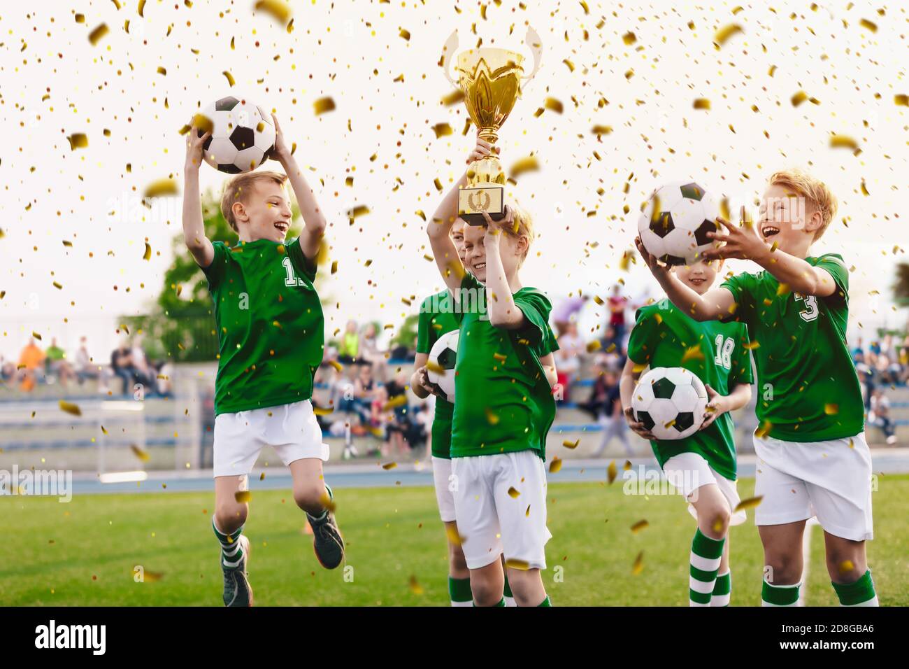 Kids celebrating sports success. Victory of children football team in tournament final game. Happy boys in school sports team winning soccer champions Stock Photo