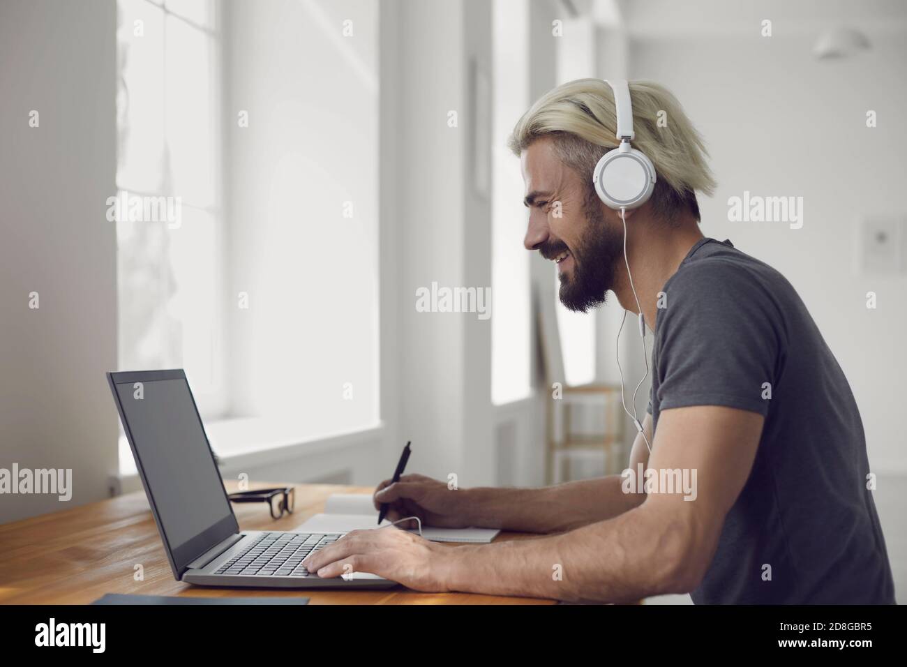 Education learning study online video call chat. Male student smiling is studying an online lesson with a teacher using a laptop webcam at home. Stock Photo