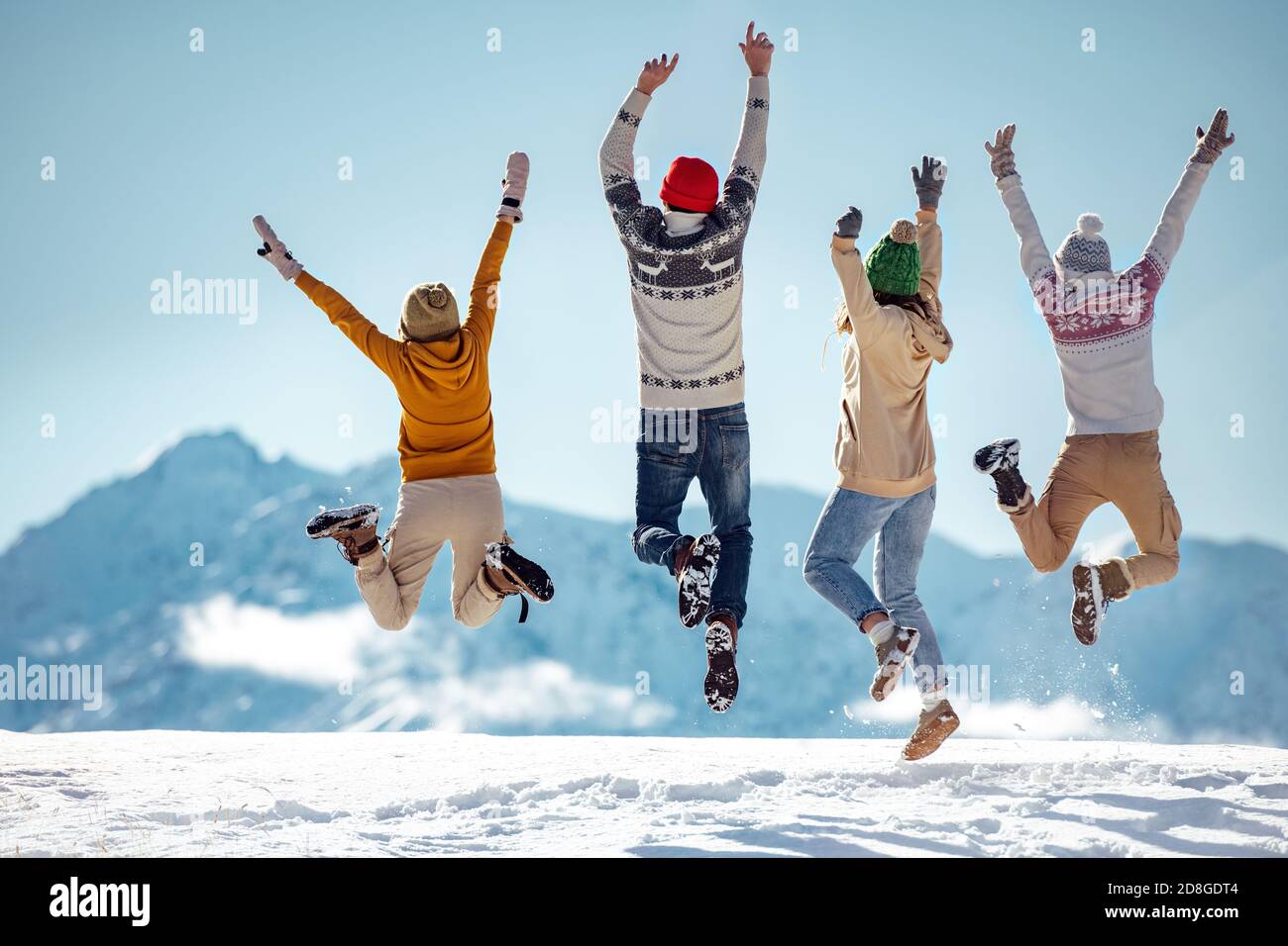 Friends celebrates beginning of winter in mountains, jumps and having fun Stock Photo