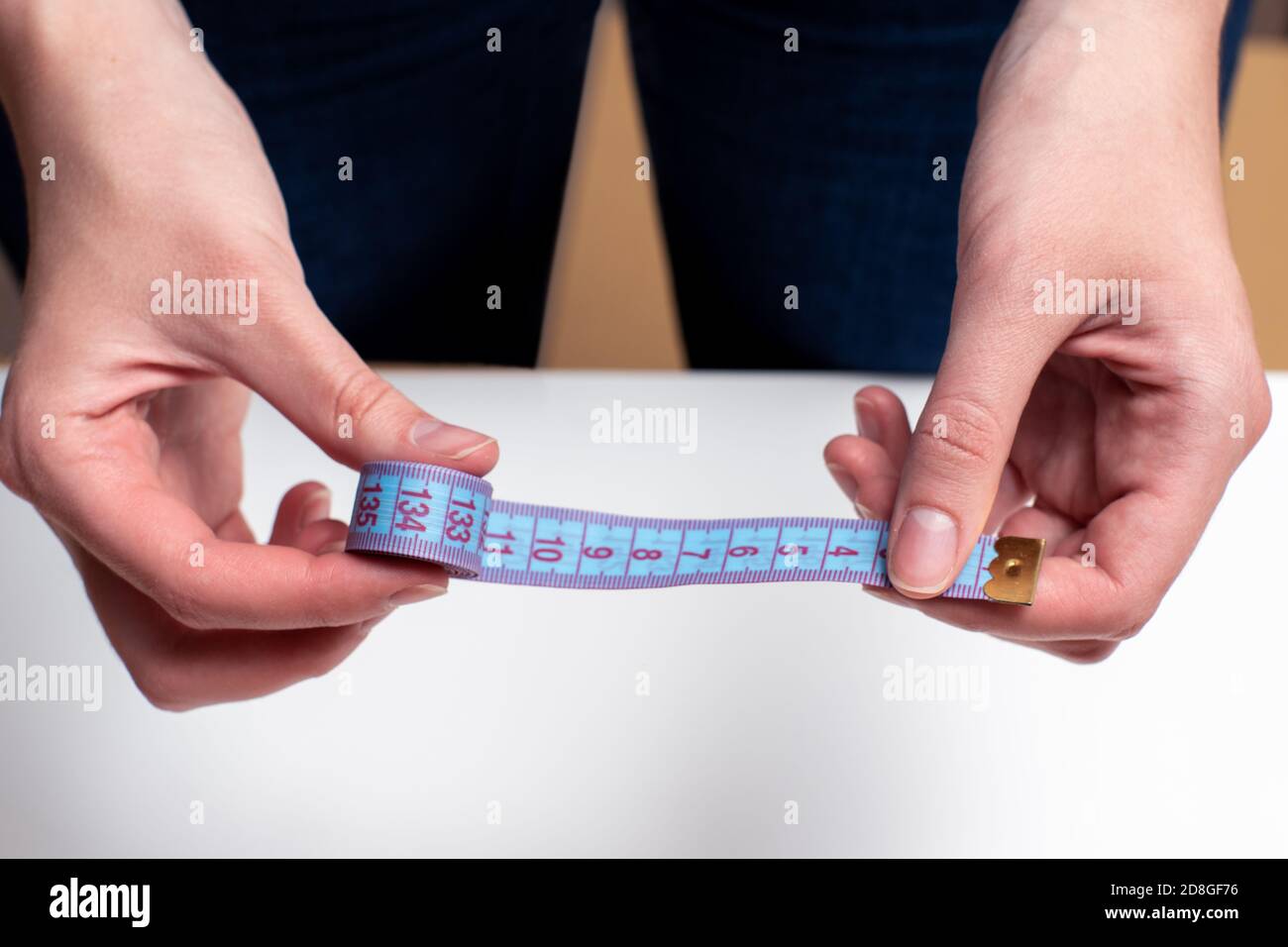 Female hands hold blue tape measure, tape measure for measuring size on
