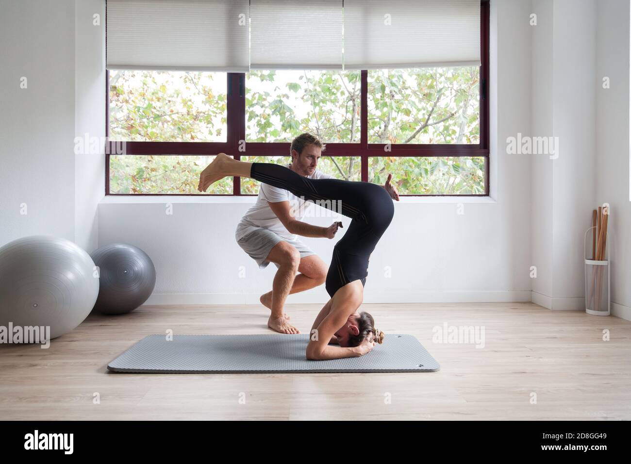 Beginner yogi and his coach practicing yoga Stock Photo