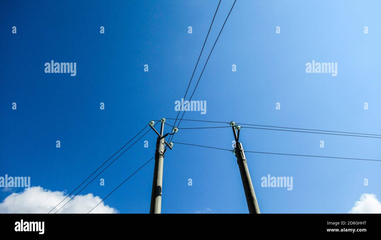 Power lines in front of a blue sky Stock Photo - Alamy