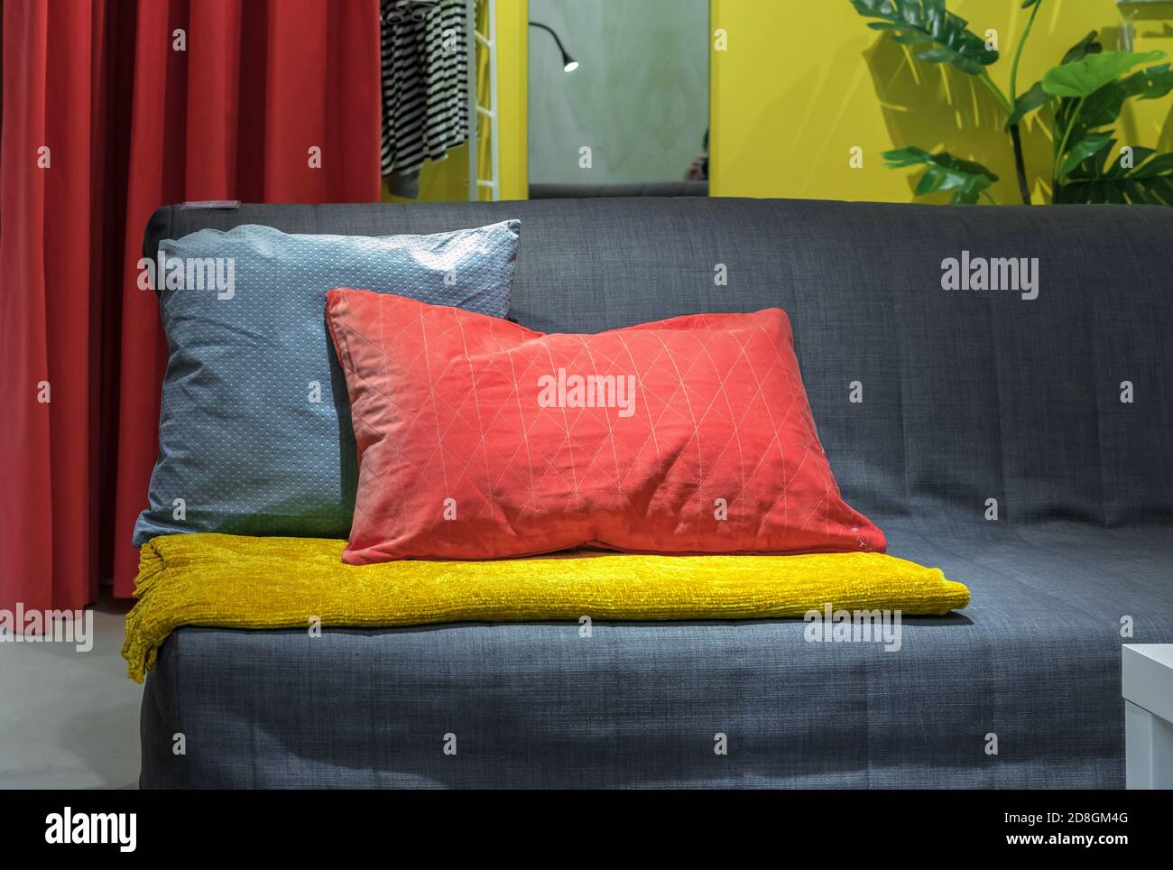 Bright decorative pillows on a gray sofa in the living room. Stock Photo