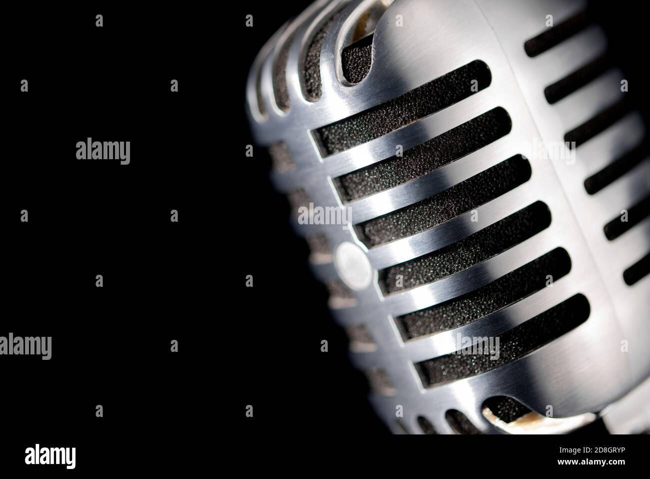 Close up of vintage / retro microphone set against a black background. Stock Photo