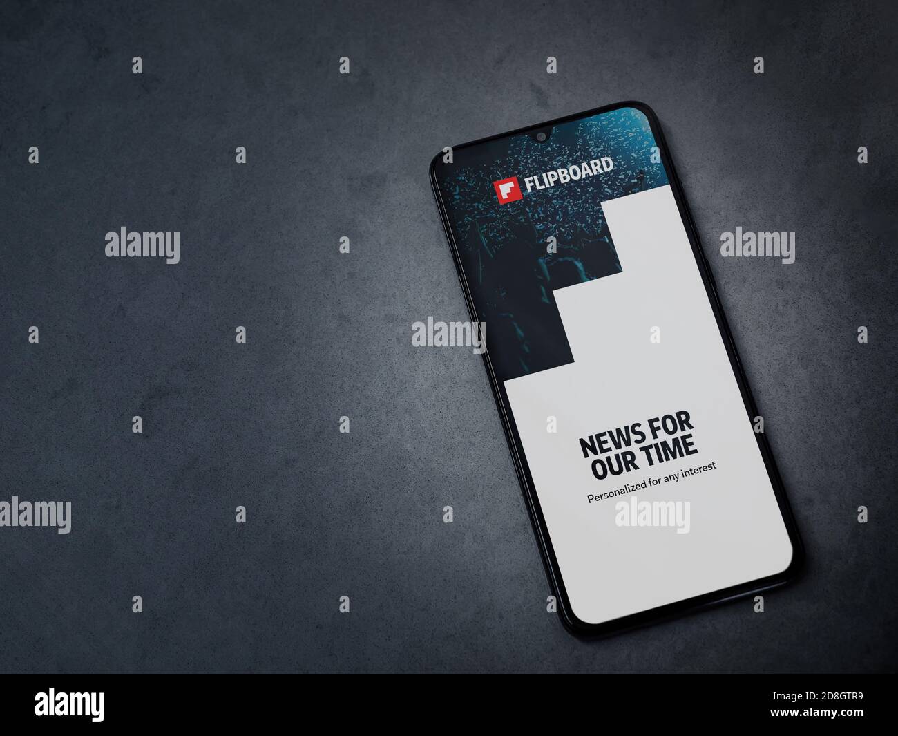 Lod, Israel - July 8, 2020: Flipboard app launch screen with logo on the display of a black mobile smartphone on dark marble stone background. Top vie Stock Photo