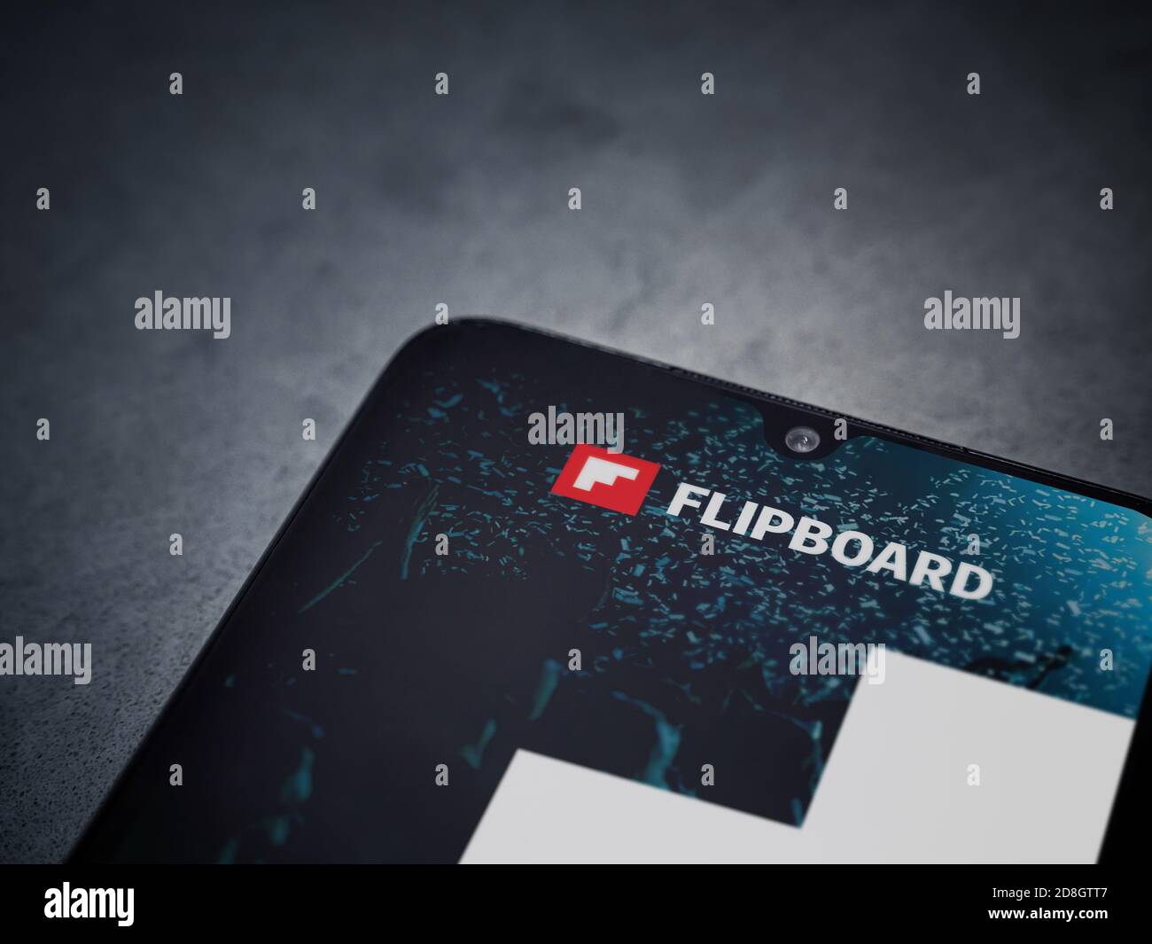 Lod, Israel - July 8, 2020: Flipboard app launch screen with logo on the display of a black mobile smartphone on dark marble stone background. Top vie Stock Photo