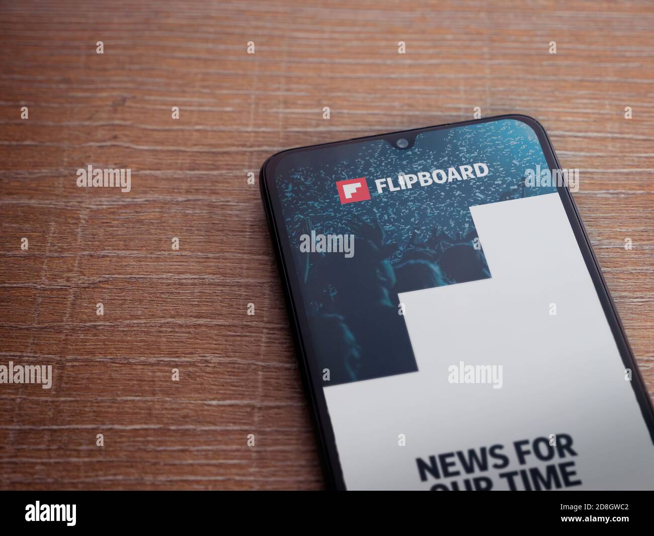 Lod, Israel - July 8, 2020: Flipboard app launch screen with logo on the display of a black mobile smartphone on wooden background. Top view flat lay Stock Photo