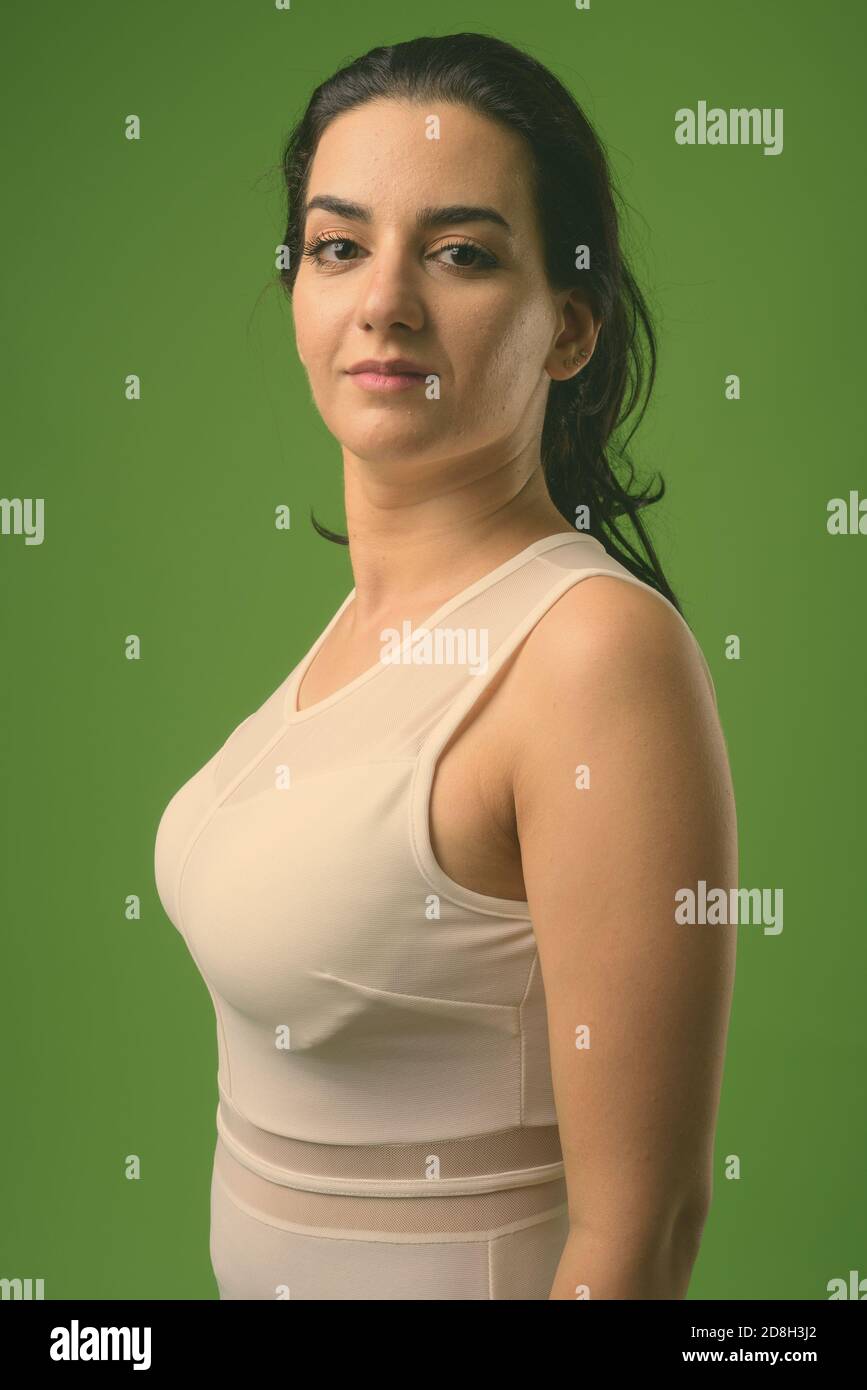 Portrait of beautiful Iranian woman against green background Stock Photo