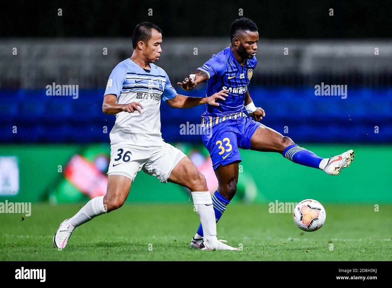 Ghanaian football player Mubarak Wakaso of Jiangsu Suning F.C., right, protects the ball during the eleventh-round match of 2020 Chinese Super League Stock Photo