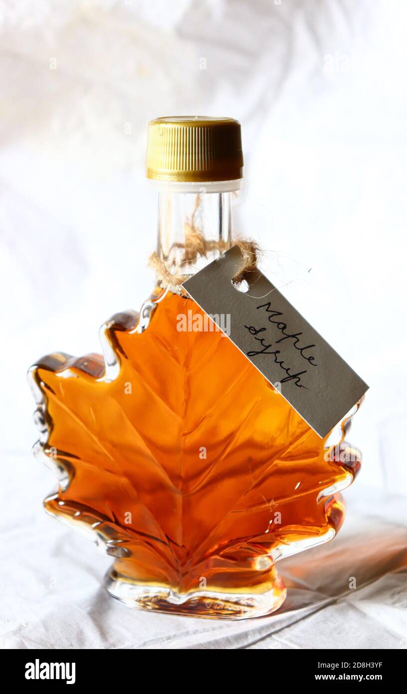 Maple syrup in a maple leaf shaped bottle, with handwritten tag against