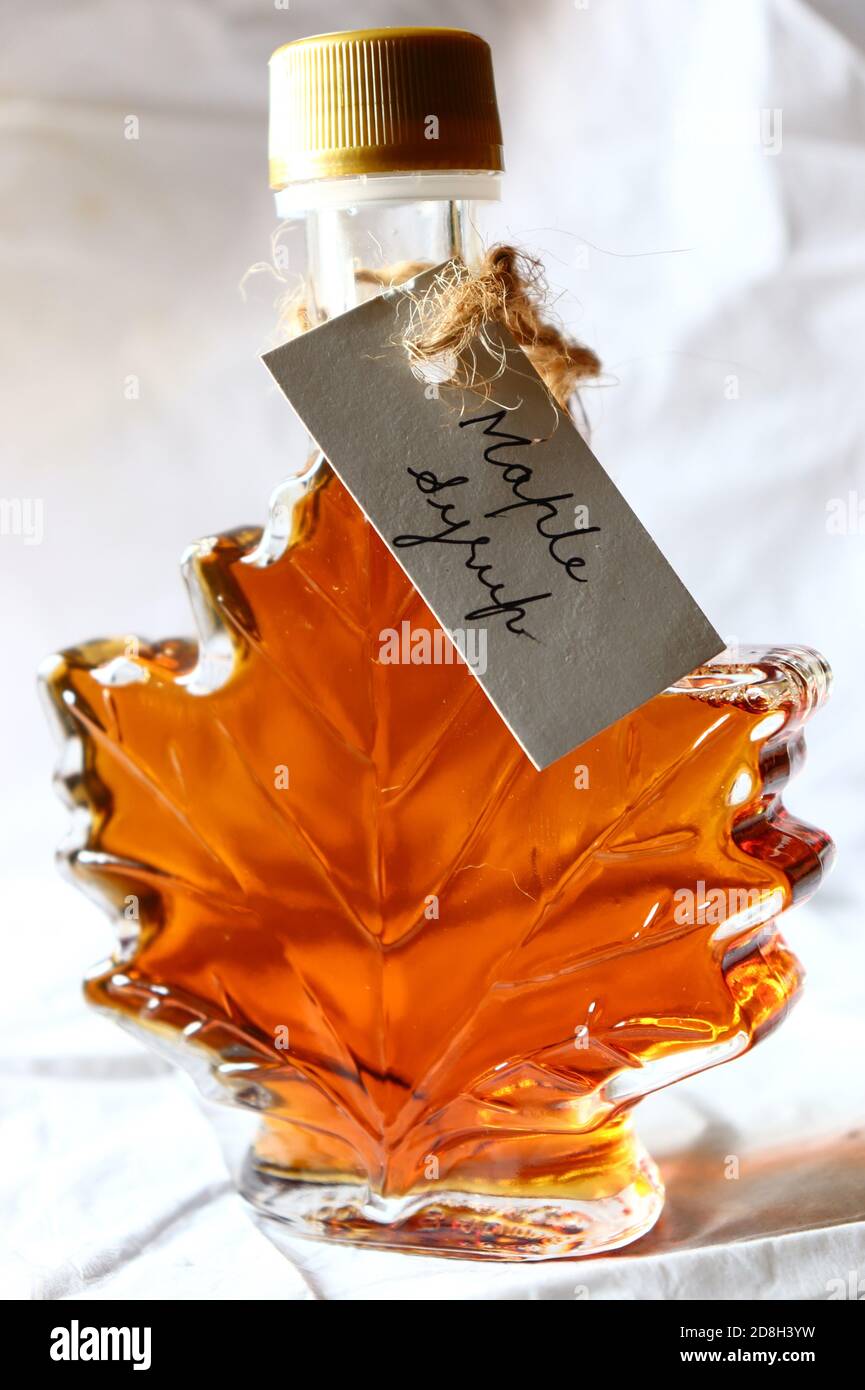 Maple syrup in a maple leaf shaped bottle, with handwritten tag against