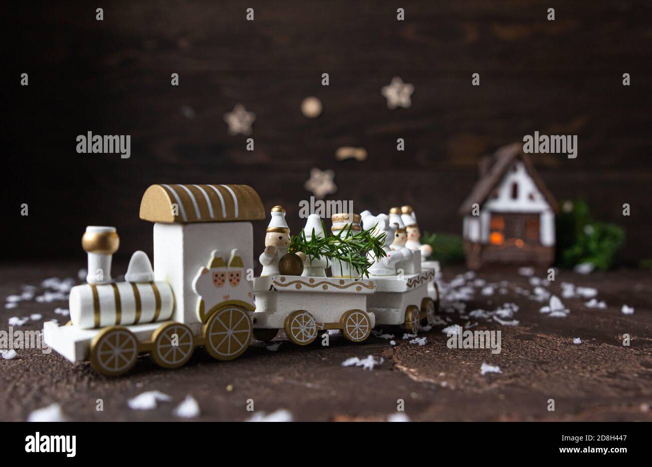 White festive Christmas wood train and house with fir branches in