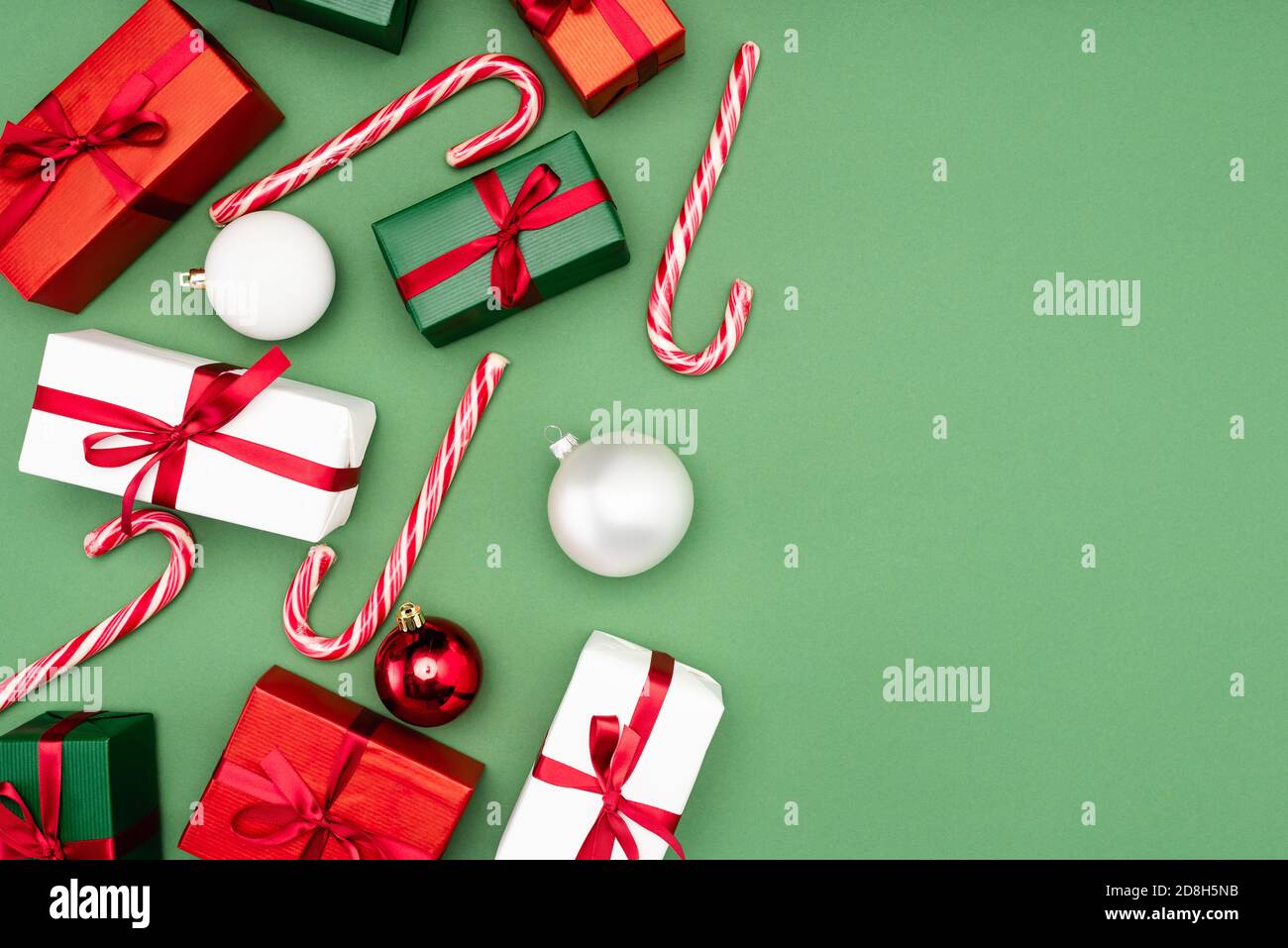 top view of multicolored gift boxes, candy canes and christmas balls on ...