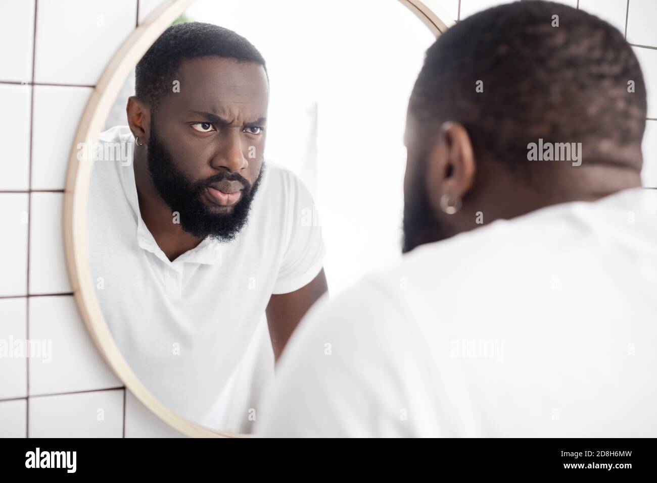https://c8.alamy.com/comp/2D8H6MW/serious-afro-american-man-looking-at-reflection-in-mirror-2D8H6MW.jpg