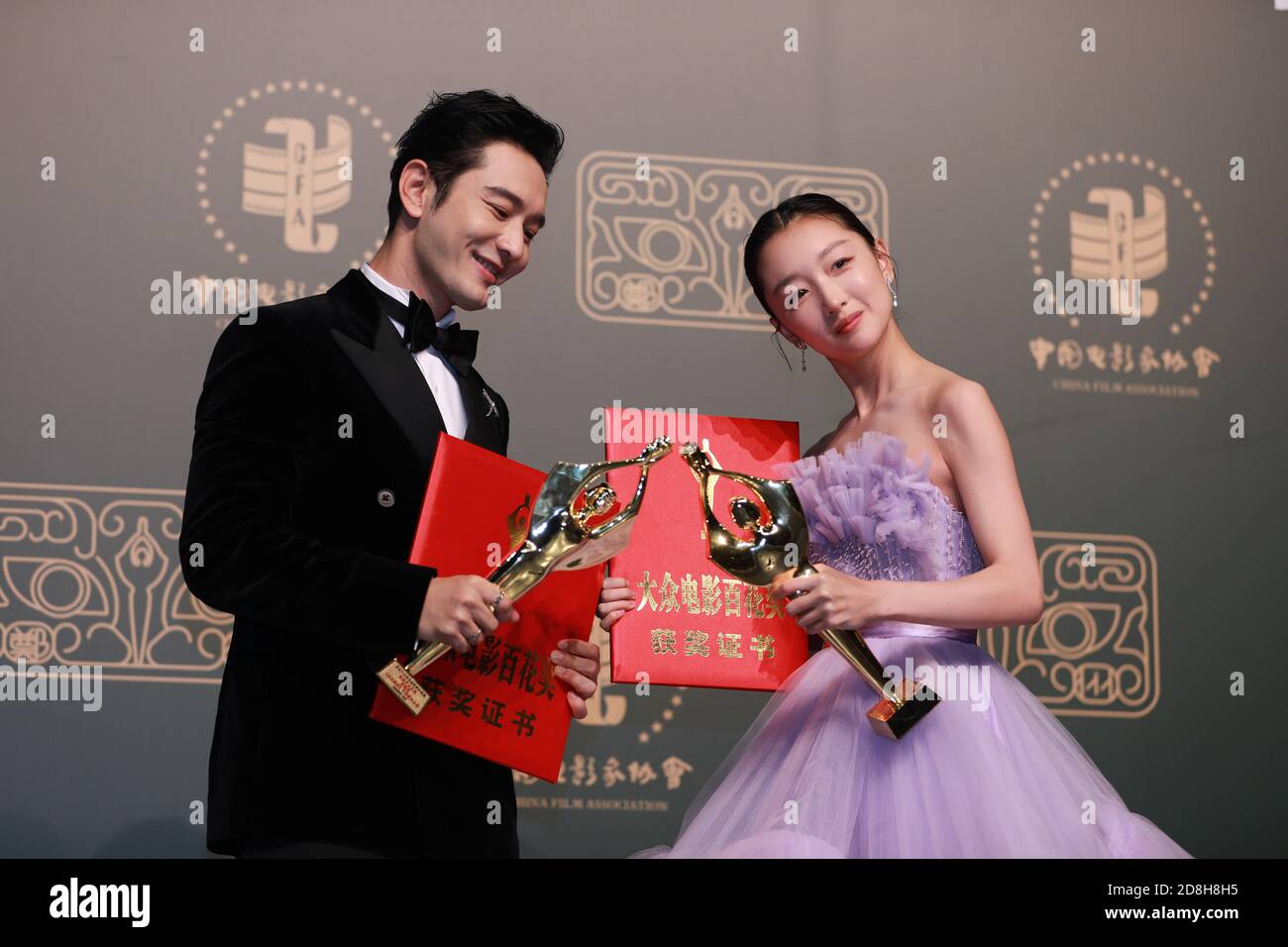 Chinese actor, singer, and model Huang Xiaoming, left and Chinese actress Zhou Dongyu show their awards at the 29th Golden Rooster Awards and the 35th Stock Photo
