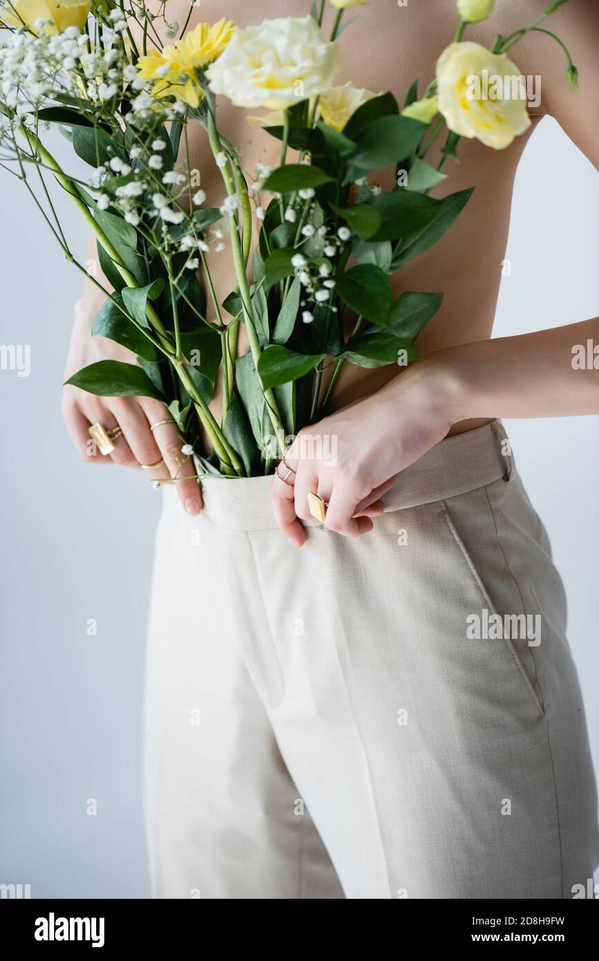 cropped view of young model touching pants with flowers on white Stock Photo