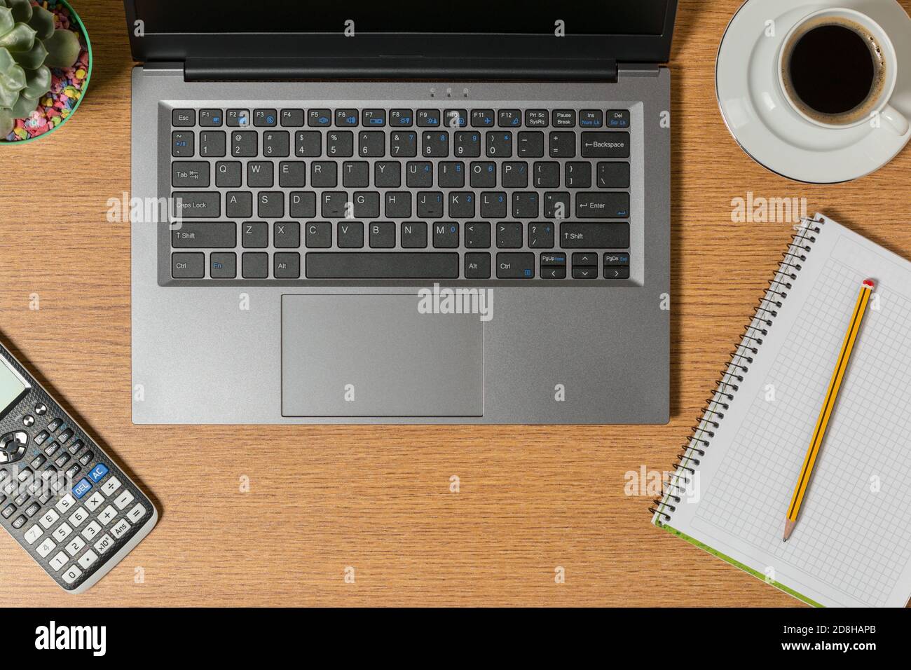 Top view of a workspace with a laptop a notepad with a pencil and a cup of coffee. Stock Photo