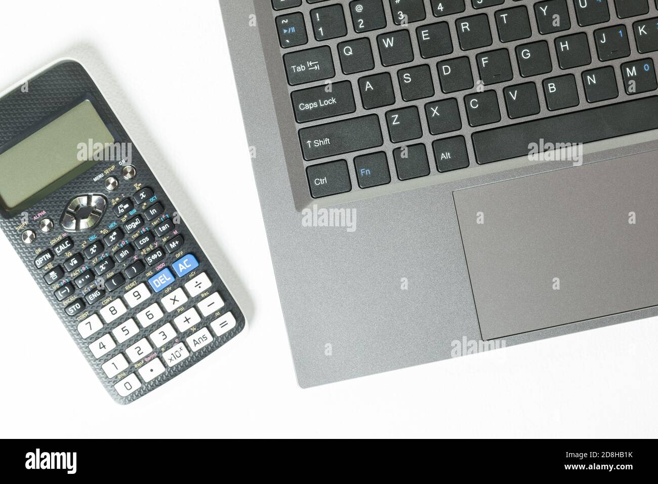 Top view of a laptop keyboard and calculator isolated on a white background. Stock Photo