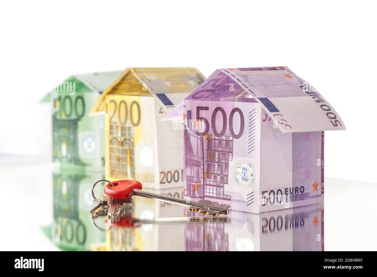 Houses made of 500, 200 and 100 euro banknotes with keys - real estate concept Stock Photo
