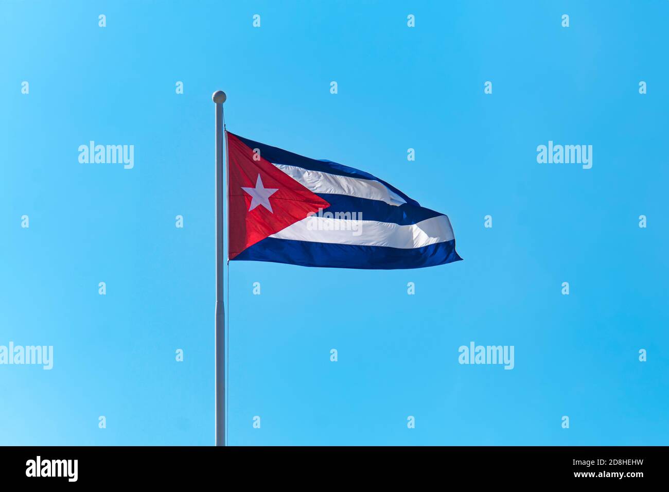 Flag of Cuba flying against blue sky. Stock Photo