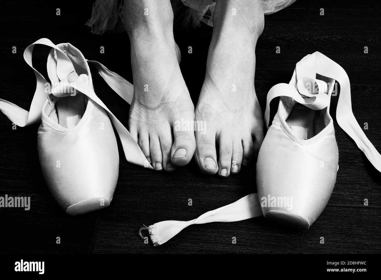 female ballerina feet with pointes after dance on a wooden floor ...